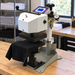 Geo Knight DC8AP heat press on a workbench with the neck of a black tee on the lower table