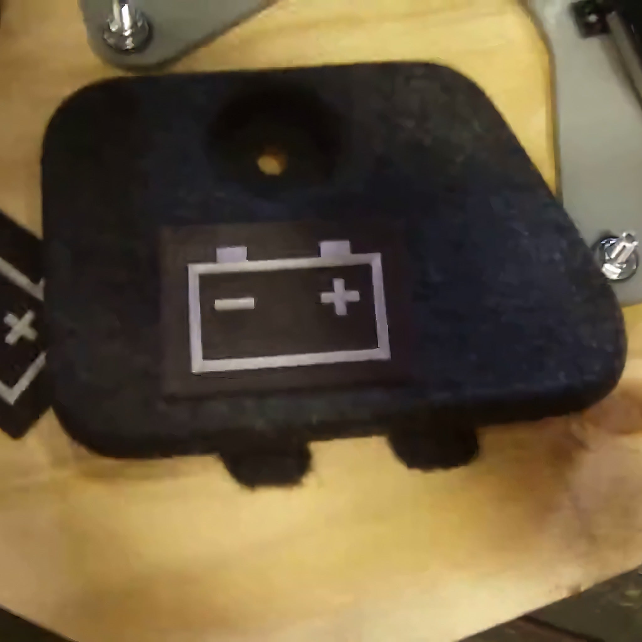 Example output: battery symbol label pressed onto a carpeted cover