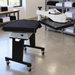 Geo Knight DK25SP heat press swung away in a print shop with a black tee on the lower table
