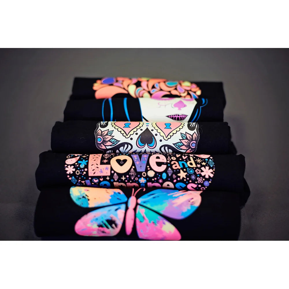 Folded black shirts printed with bright sugar skull and butterfly designs from the IColor Textile Sample Paper Kit