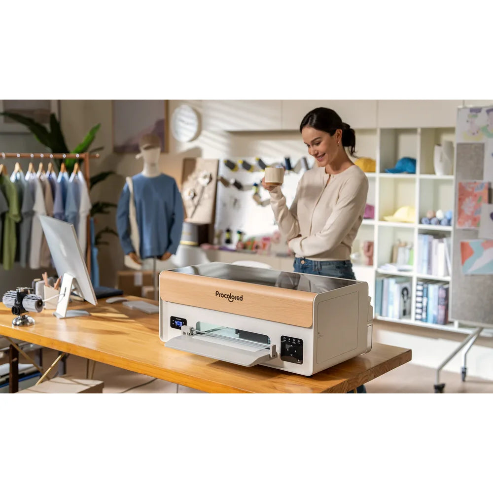 Woman standing beside the procolored p13 DTF printer in an apparel studio with clothing racks and a monitor in the background