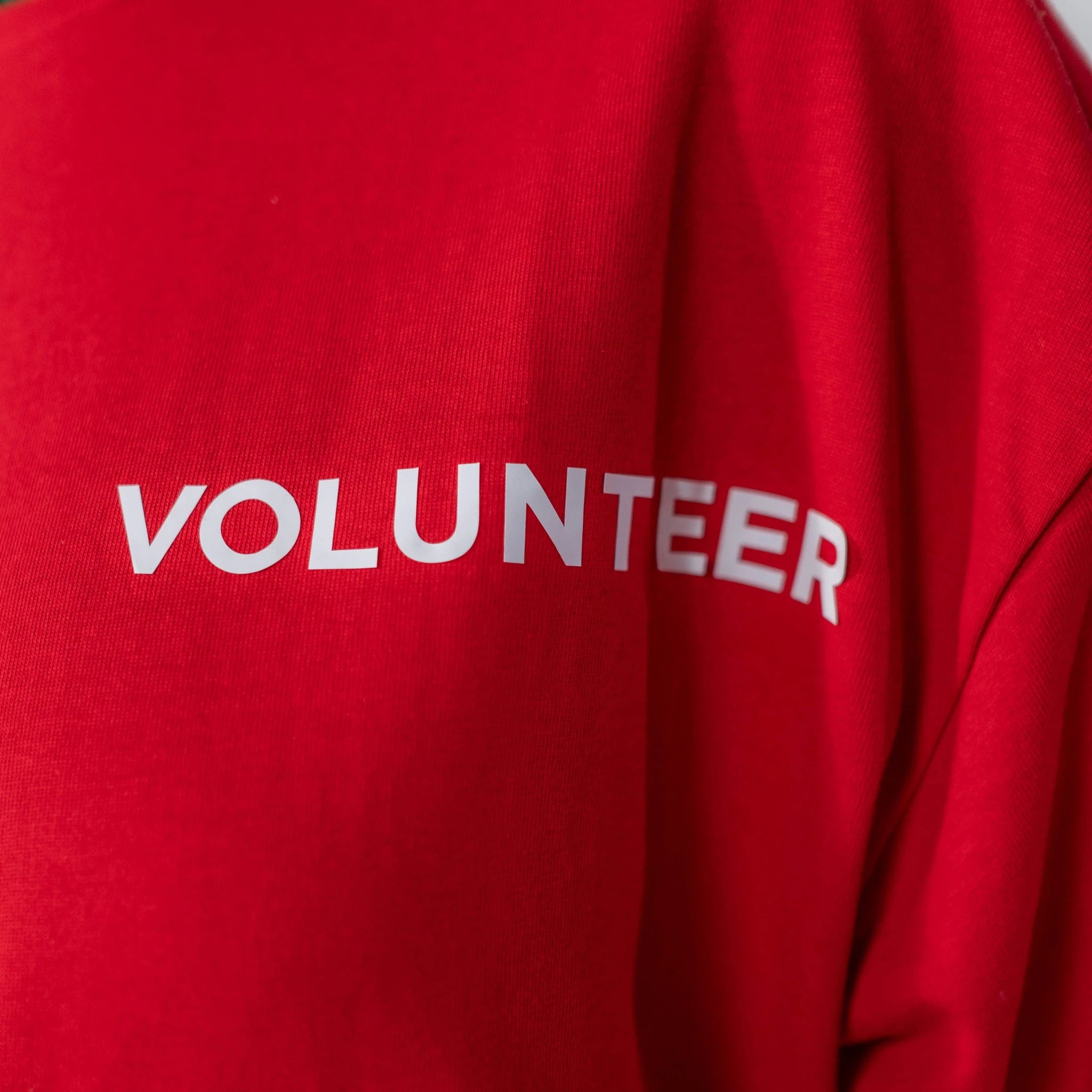 Example of garment work for the Geo Knight DC16 Digital Combo Machine: red sweatshirt with a white VOLUNTEER print