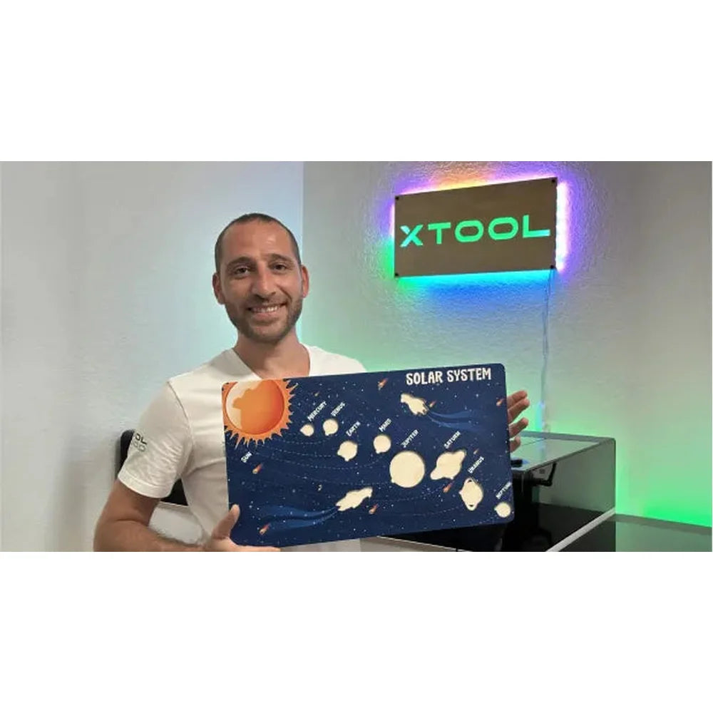 Solar-system panel held beside the xTool O1 Omni Printer 4-in-1 and an illuminated wall sign