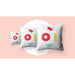 Three white cushions with colorful geometric prints made using the icolor 350 printer, staged on a soft pink background