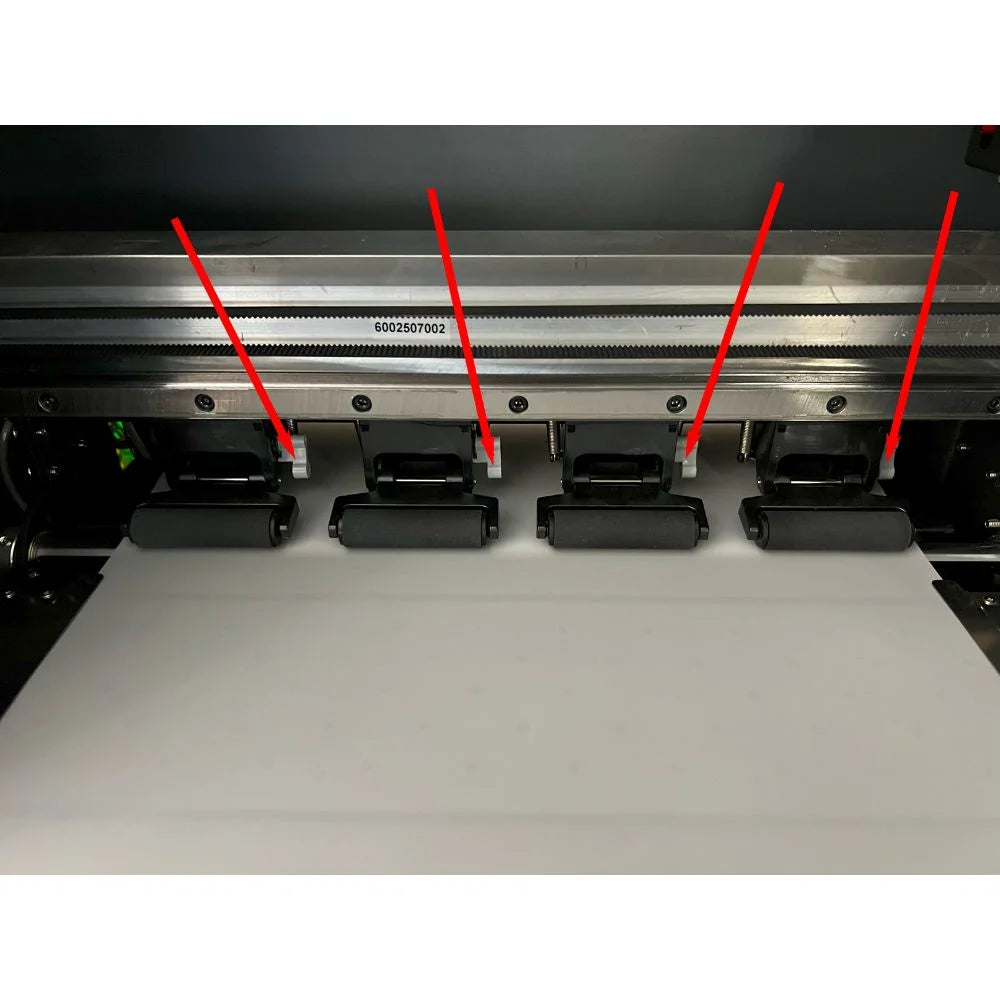 Annotated interior view of the uninet 1200 dtf printer showing four film pinch rollers holding white film flat on the platen