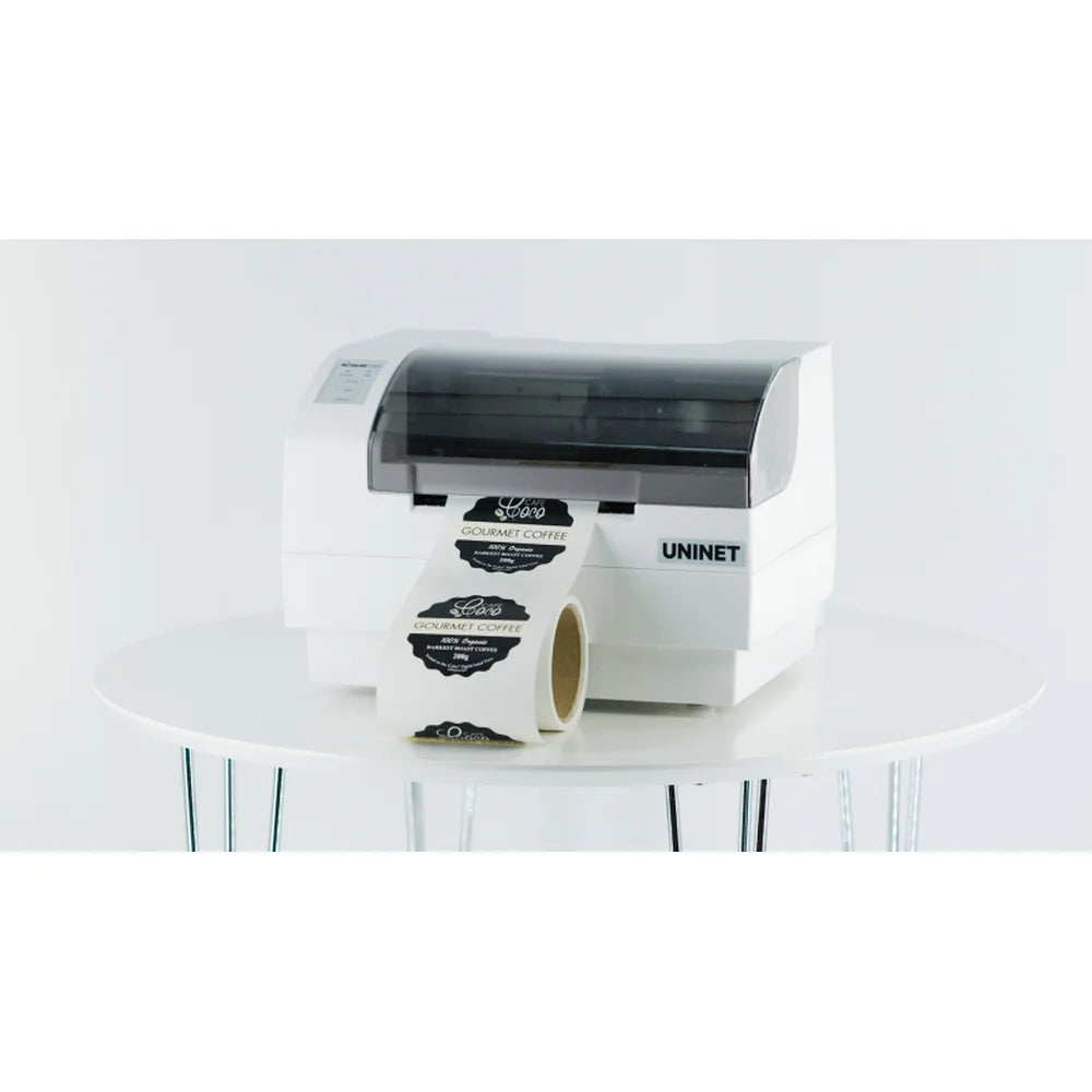 UNINET Label Printer producing black gourmet coffee labels from a continuous roll on a studio table