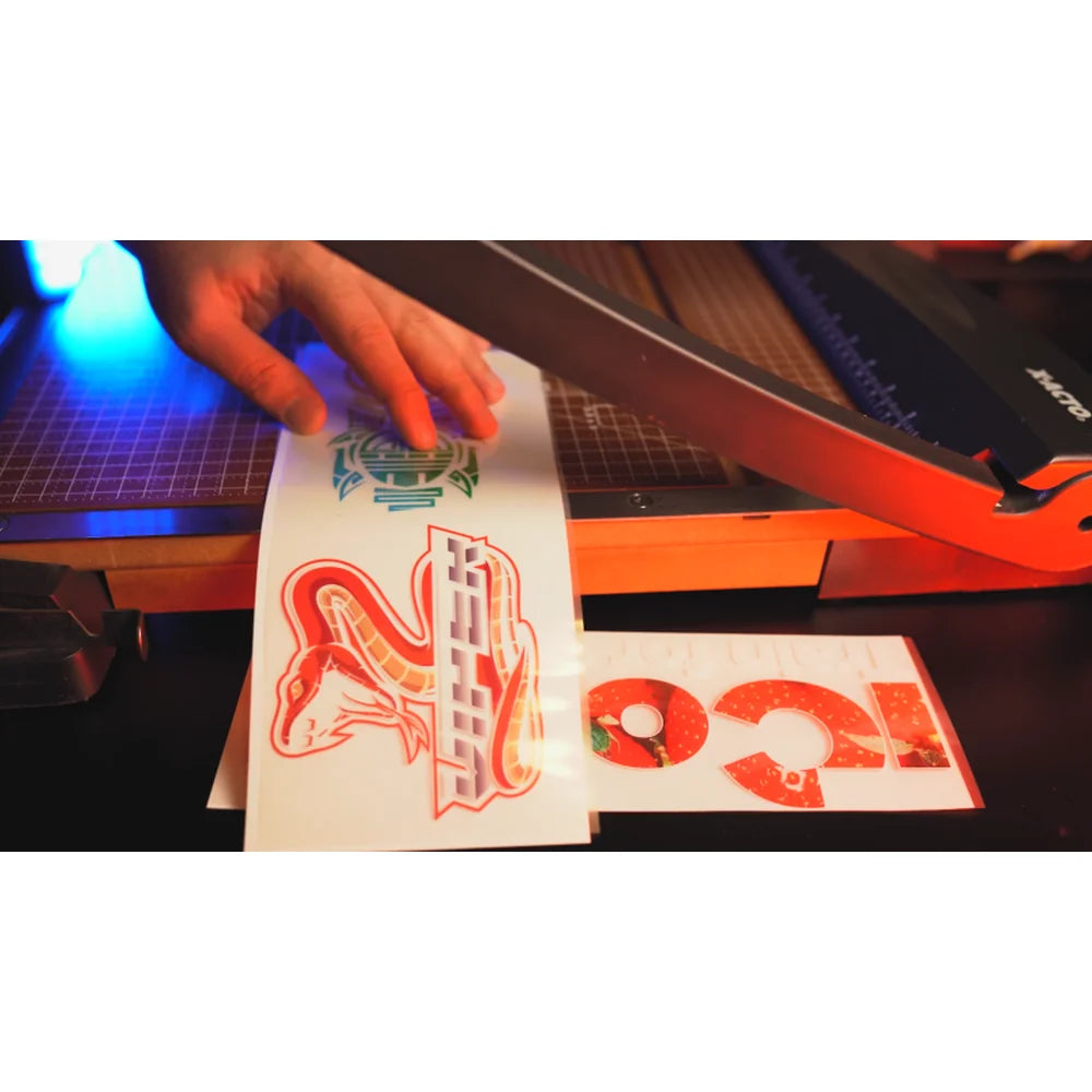 Hand trimming printed laser transfer sheets on a cutting mat as taught in the UNINET White Toner Master Class using a paper trimmer