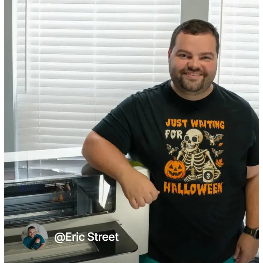 Owner in a Halloween shirt standing beside the xTool Apparel Printer in a home workroom